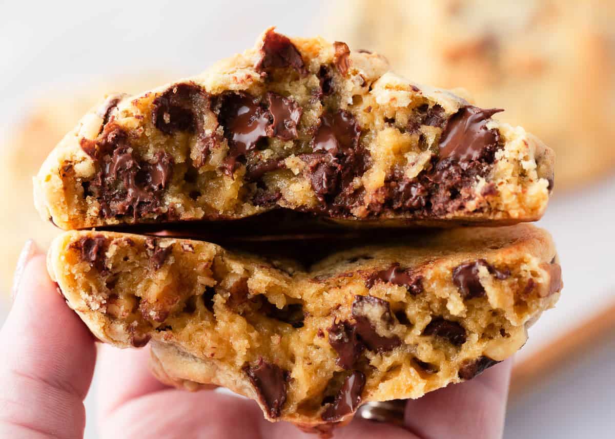 Holding a Levain bakery chocolate chip cookie split in half.