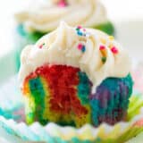 Rainbow cupcake biten into.