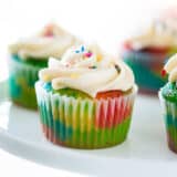 Rainbow cupcakes on cake stand.