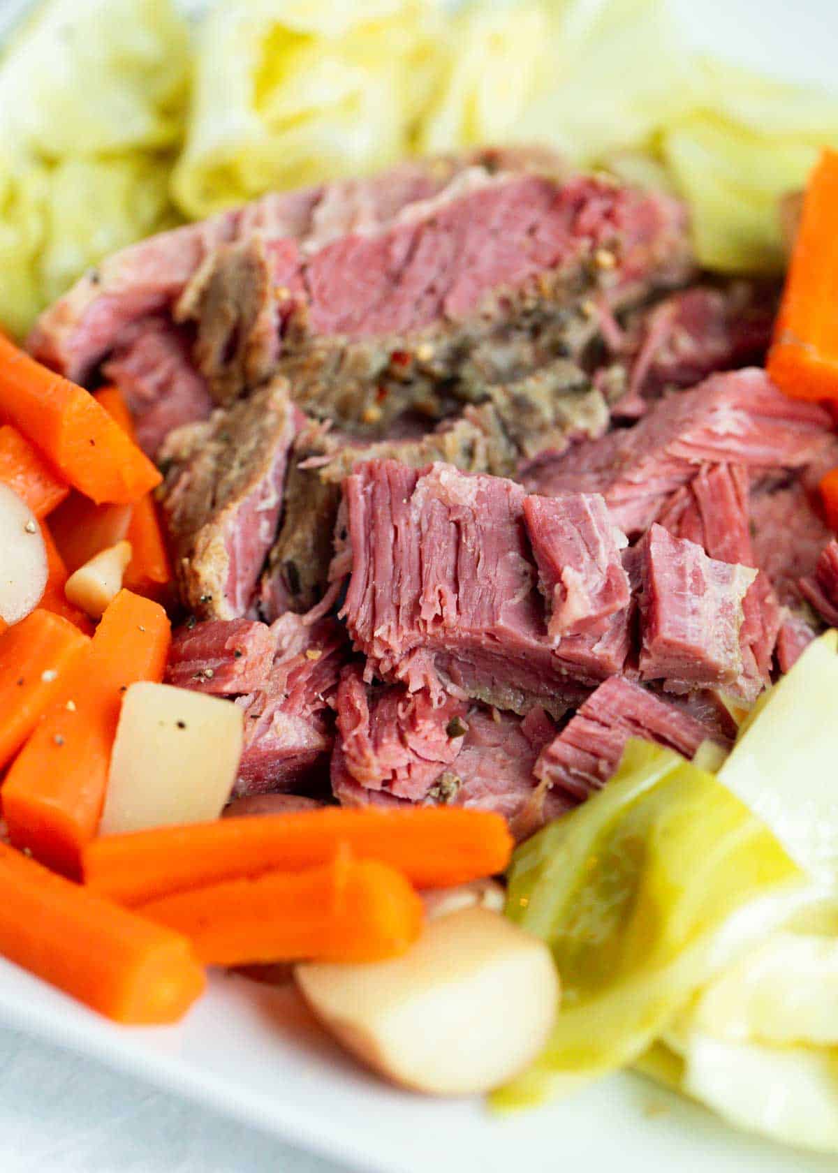 Corned beef and cabbage on a white plate.