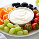 Fruit dip and fruit on a plate.