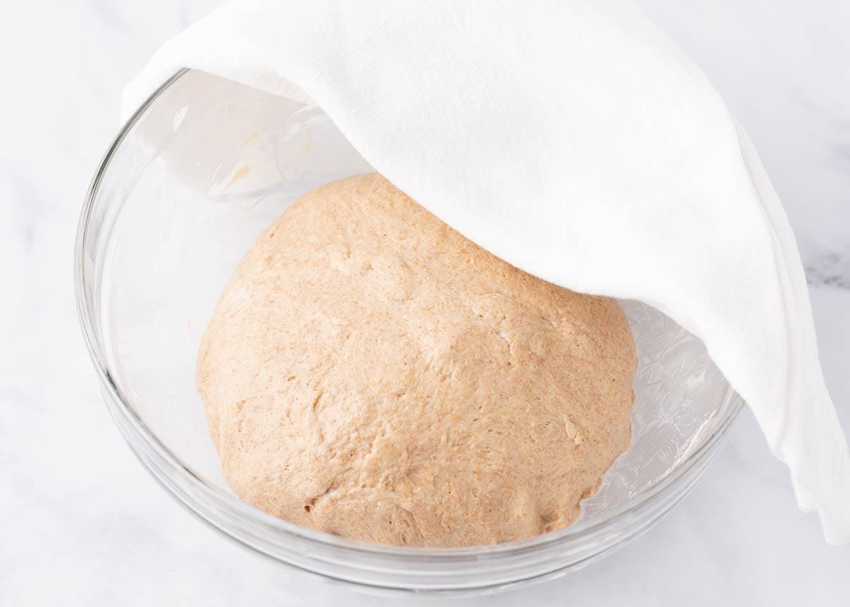 Covering the dough with a clean kitchen towel and let it rise in a warm, draft-free spot
