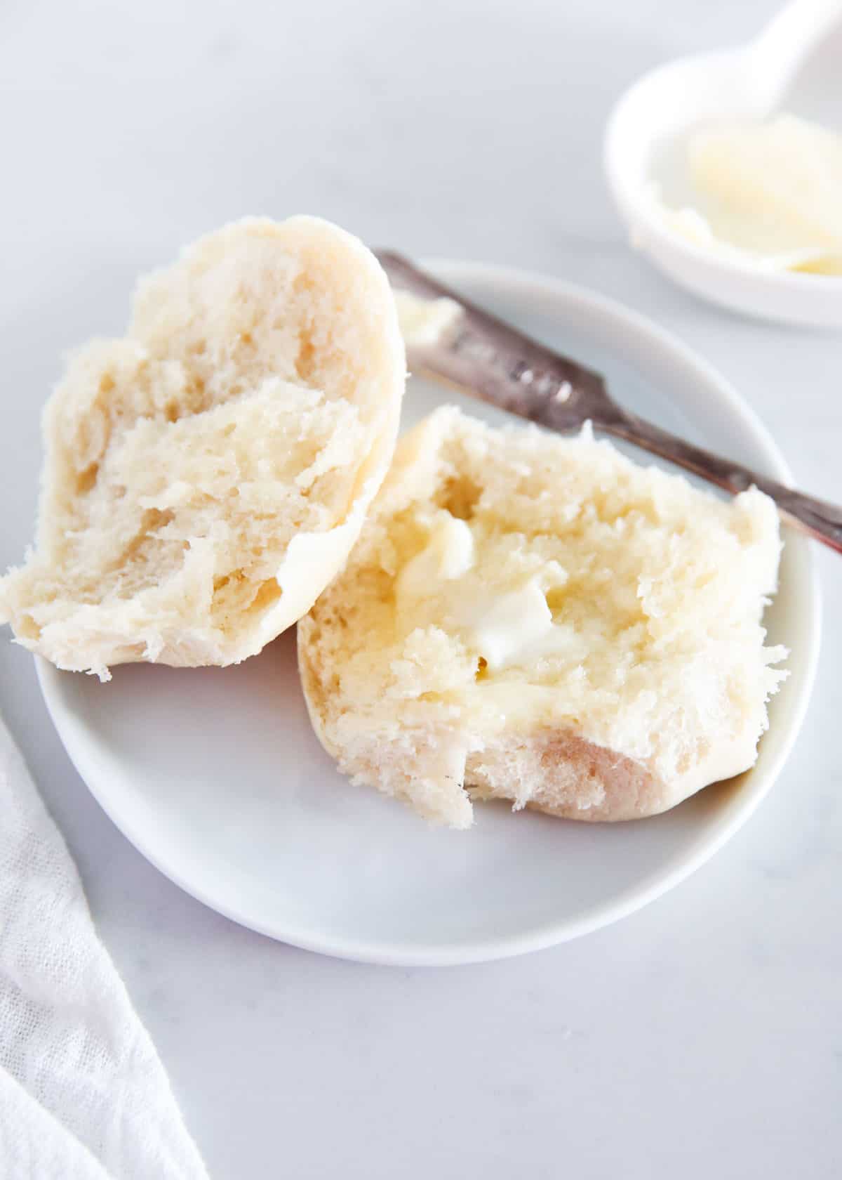 French bread roll split open with butter on top.