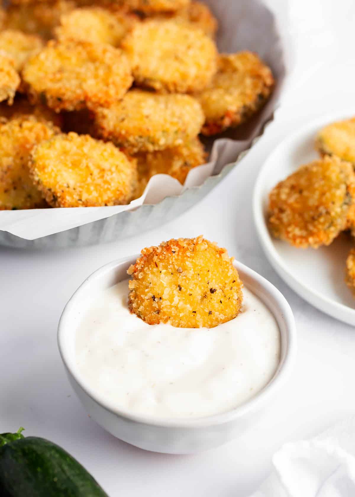 Dipping fried zucchini in ranch.
