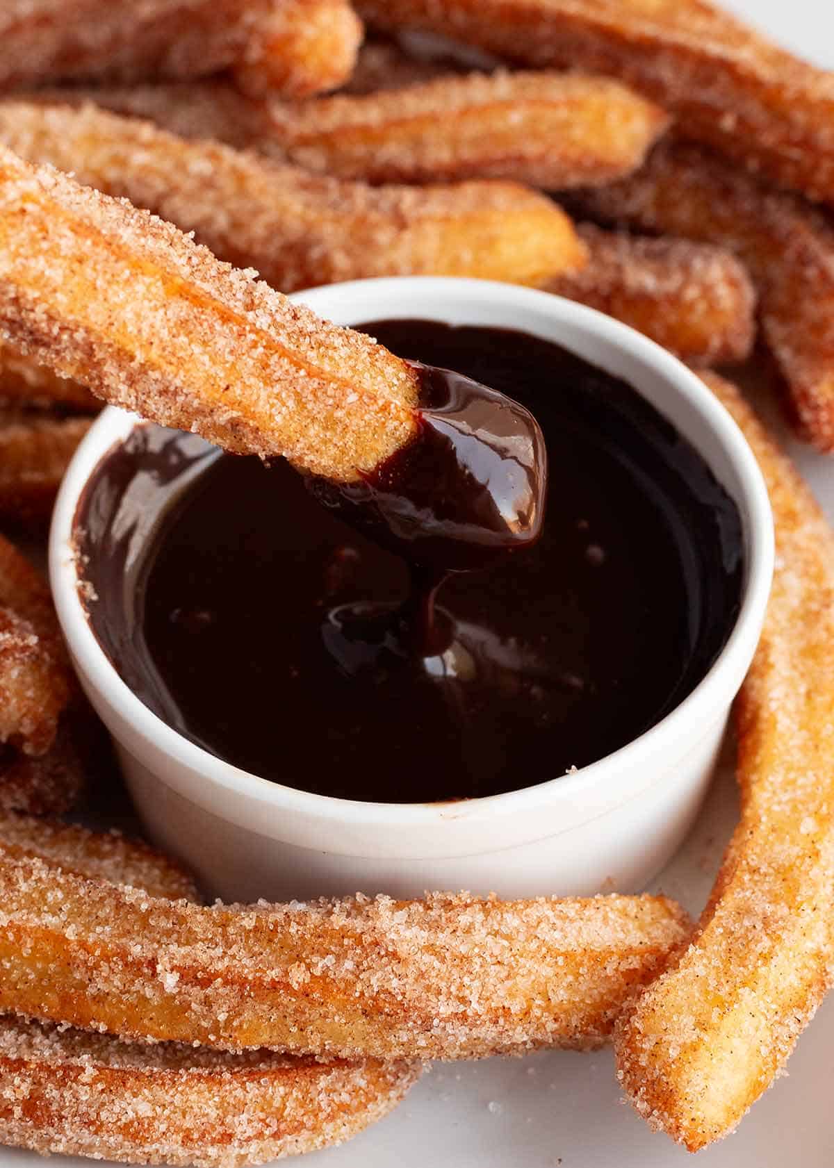 Dipping a churro in chocolate.