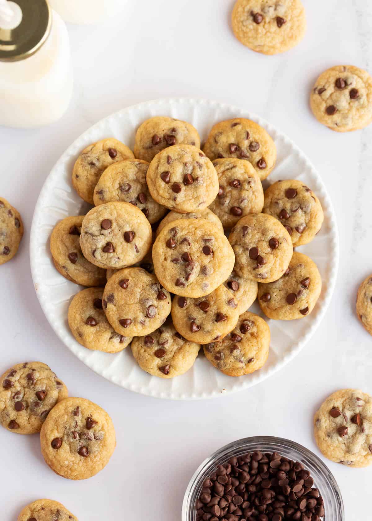 Mini chocolate chip cookies on a white plate.
