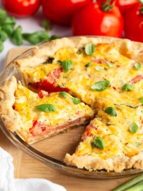 Close-up of tomato basil pie with cheesy mayo topping and layered tomatoes.