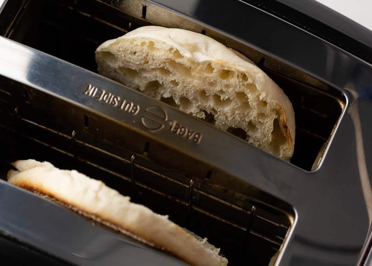 Toasting an english muffin in a toaster.
