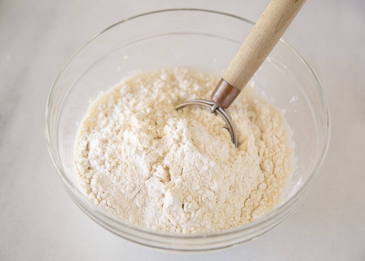 Mixing flour in a glass bowl.