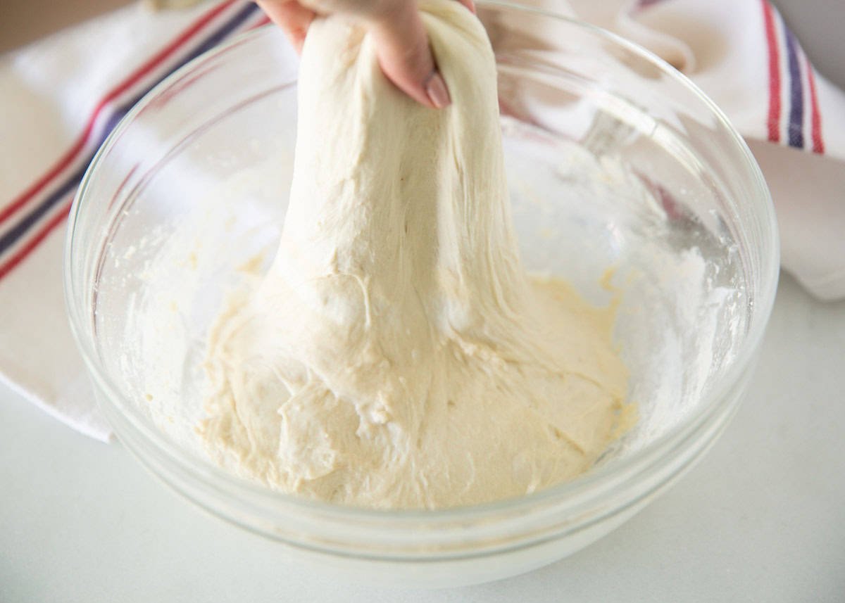 Pulling sourdough bread in glass bowl.