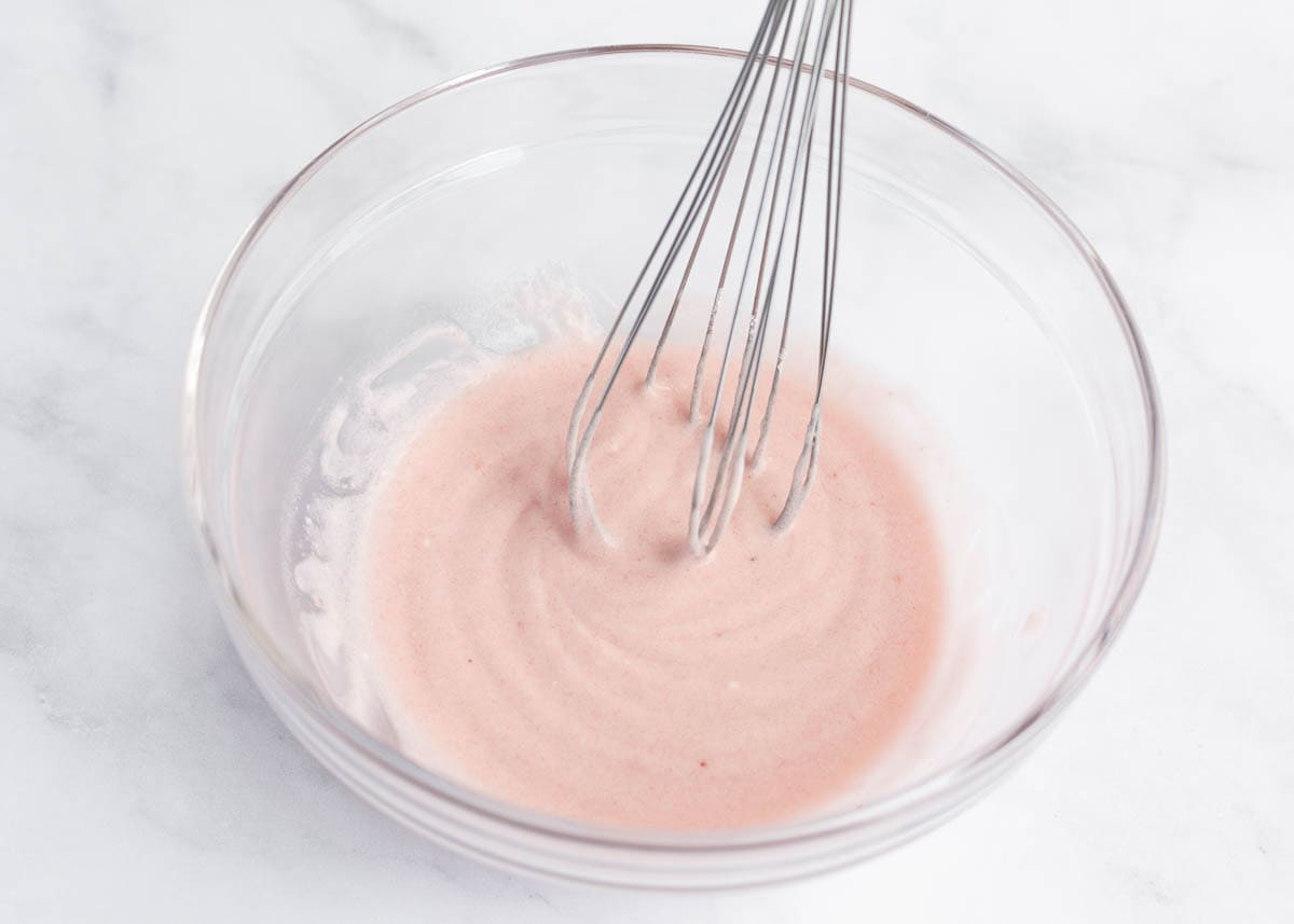 Making strawberry glaze in a small bowl.