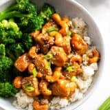 Cashew chicken in a bowl with rice and broccoli.