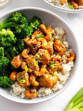 Cashew chicken in a bowl with rice and broccoli.