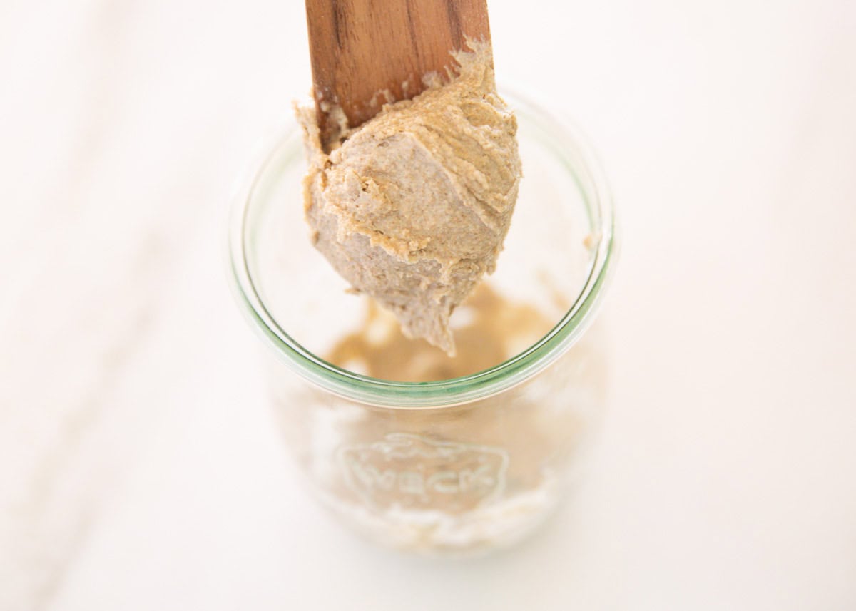 Mixing sourdough starter with a spoon.