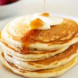 Pouring syrup on sourdough pancakes.