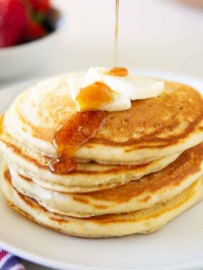 Pouring syrup on sourdough pancakes.