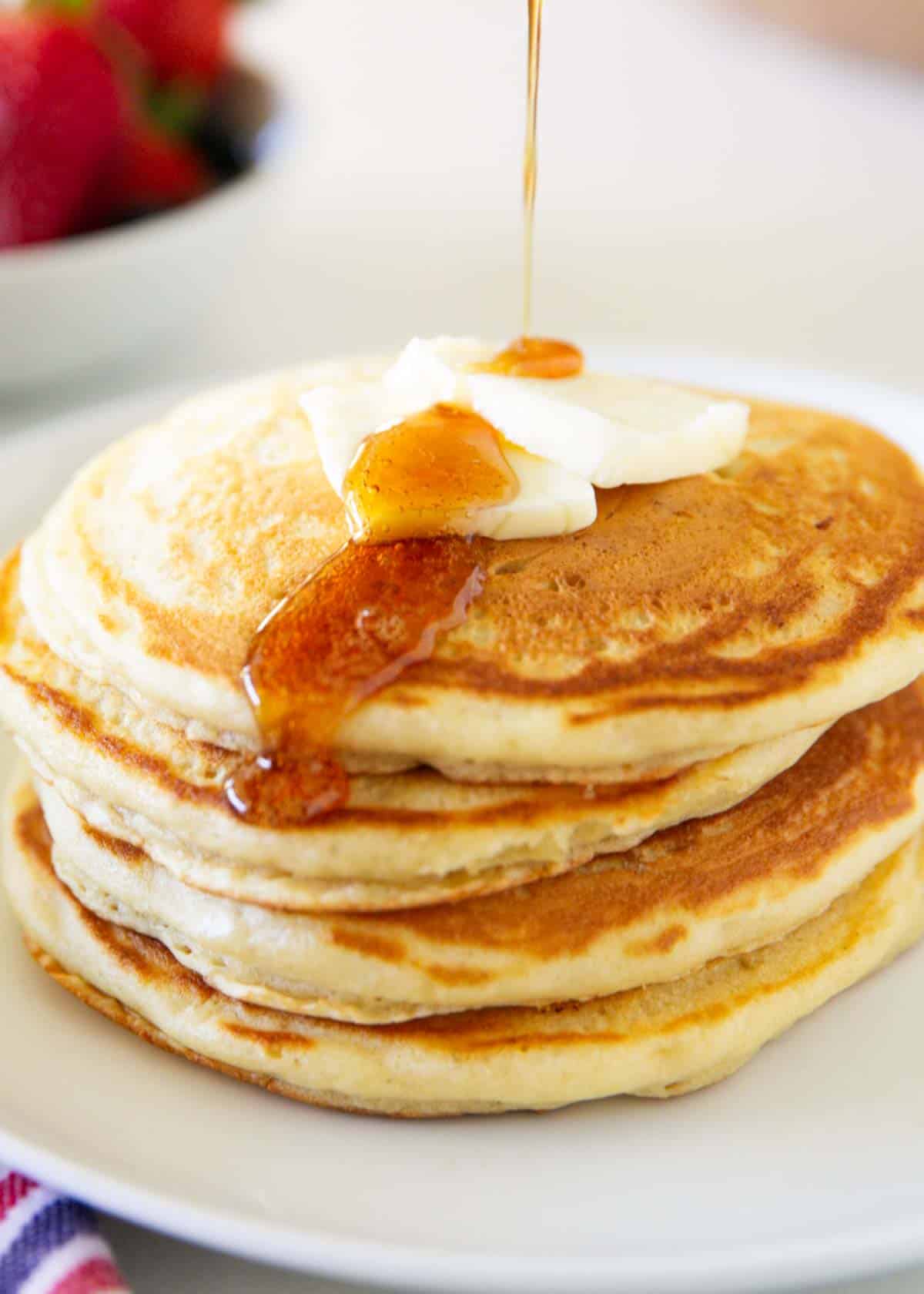 Pouring syrup on sourdough pancakes.