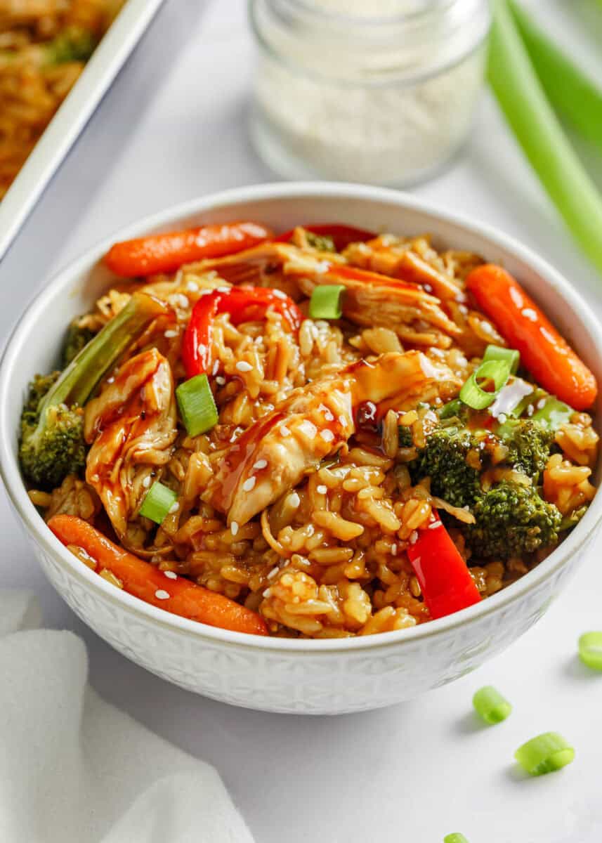All you need for this easy chicken teriyaki casserole is chicken, cooked rice, veggies, and teriyaki sauce for a quick, healthy, and flavorful meal any night of the week! Teriyaki chicken casserole in a white bowl.
