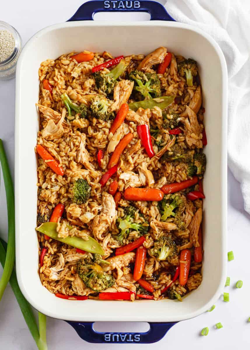 All you need for this easy chicken teriyaki casserole is chicken, cooked rice, veggies, and teriyaki sauce for a quick, healthy, and flavorful meal any night of the week! Teriyaki chicken casserole in a white baking dish.