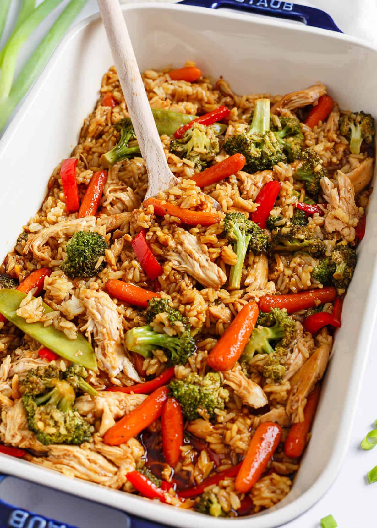 All you need for this easy chicken teriyaki casserole is chicken, cooked rice, veggies, and teriyaki sauce for a quick, healthy, and flavorful meal any night of the week! Teriyaki chicken casserole in a white baking dish with serving spoon.