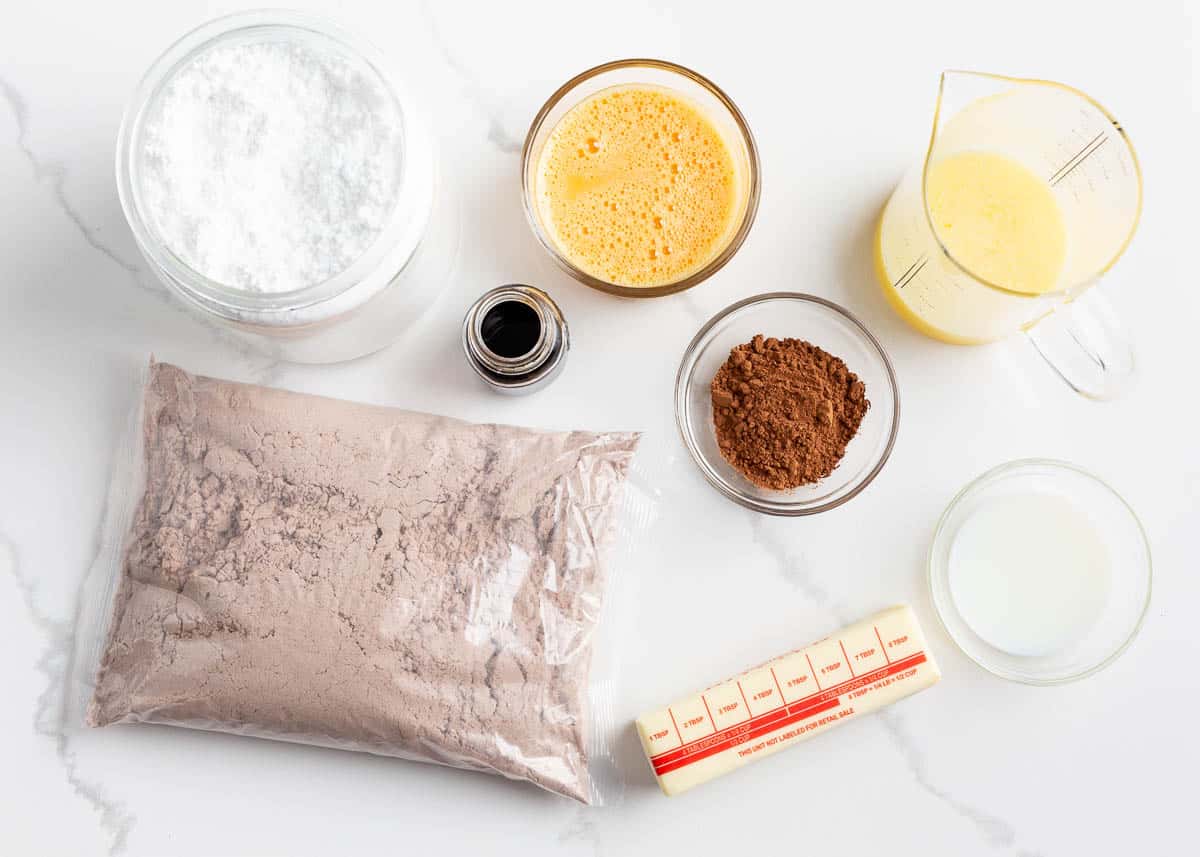 Grab your boxed cake mix, eggs, and butter, make a batch of 24 fudgy Texas sheet cake cookies, and add a delicious Texas sheet cake frosting on top! Texas sheet cake cookie ingredients on counter.