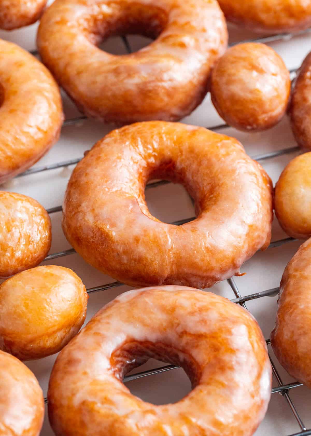 Homemade glazed donuts on a wire baking rack.