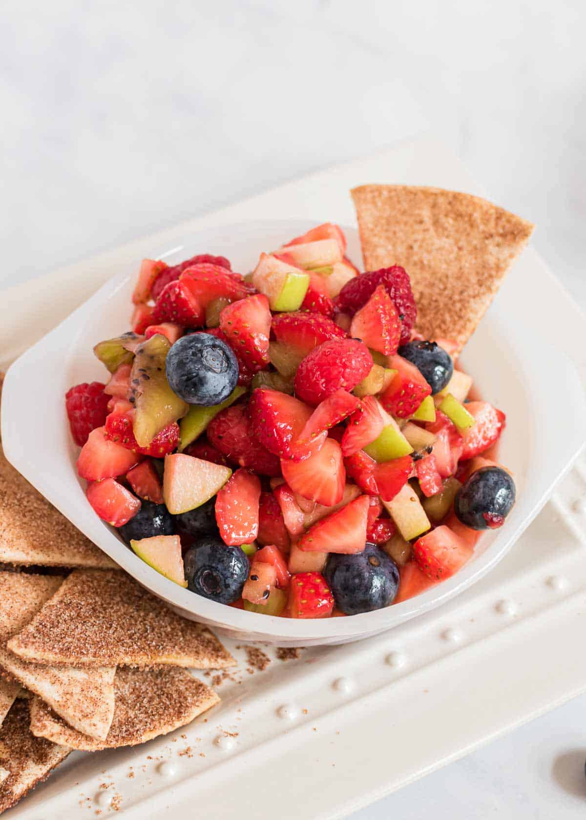 These cinnamon tortilla chips are crispy, golden and full of cinnamon sugar taste. They are easy to make and the perfect pair to fruit salsas or sweet dessert dips! Cinnamon tortilla chips and fruit salsa.