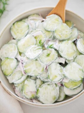 Creamy cucumber salad with dill, featuring crisp English cucumbers, sour cream dressing, and flecks of fresh dill.
