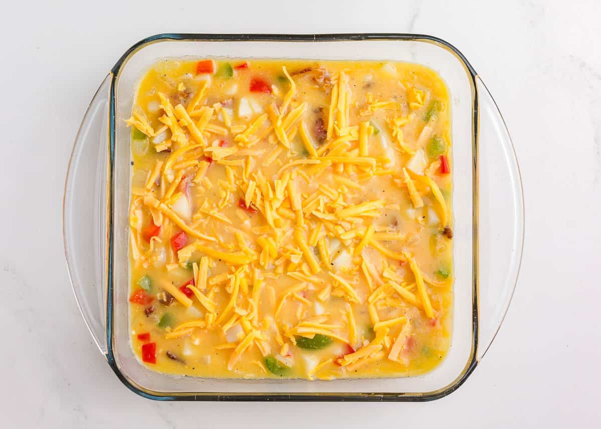 Assembled bacon, potato and egg casserole in baking dish.