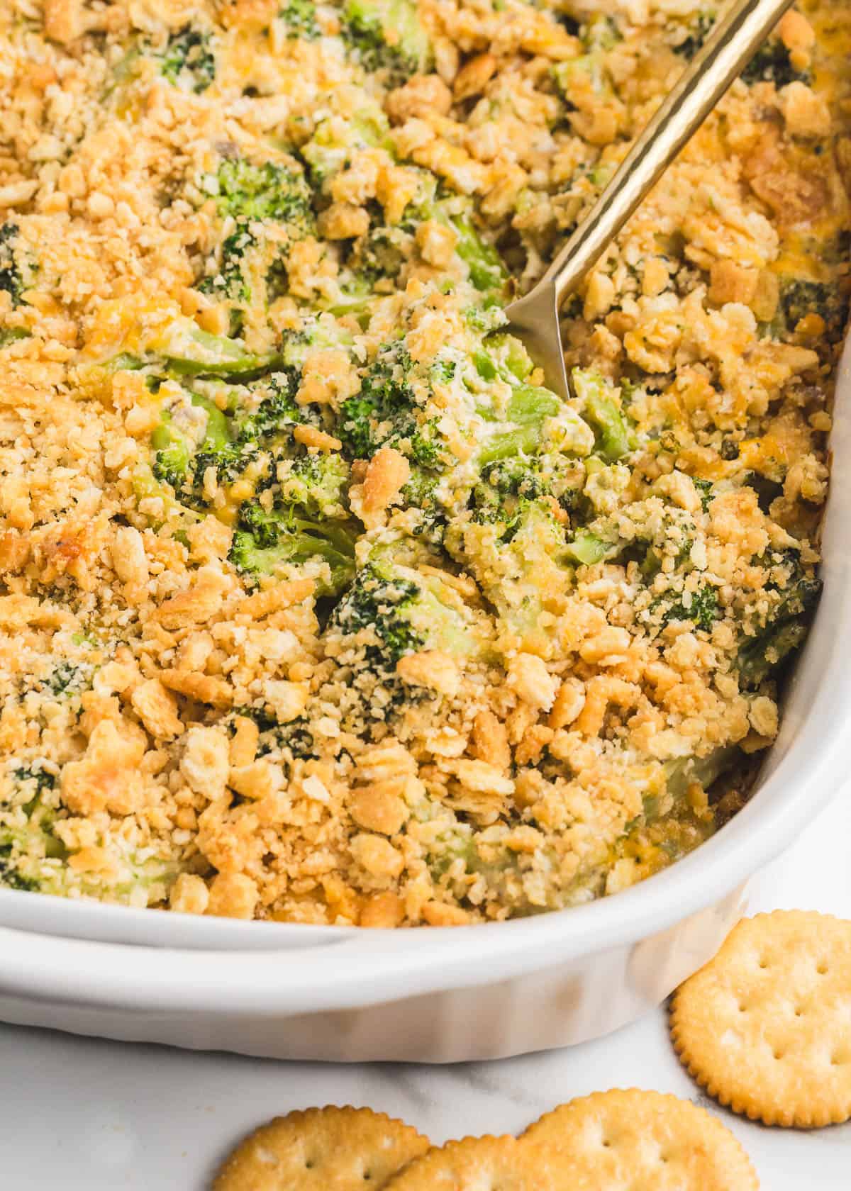 This broccoli cheese casserole recipe made with a creamy cheese sauce and a Ritz cracker topping is both easy to make and a crowd-pleasing side dish! Broccoli cheese casserole in a baking dish.