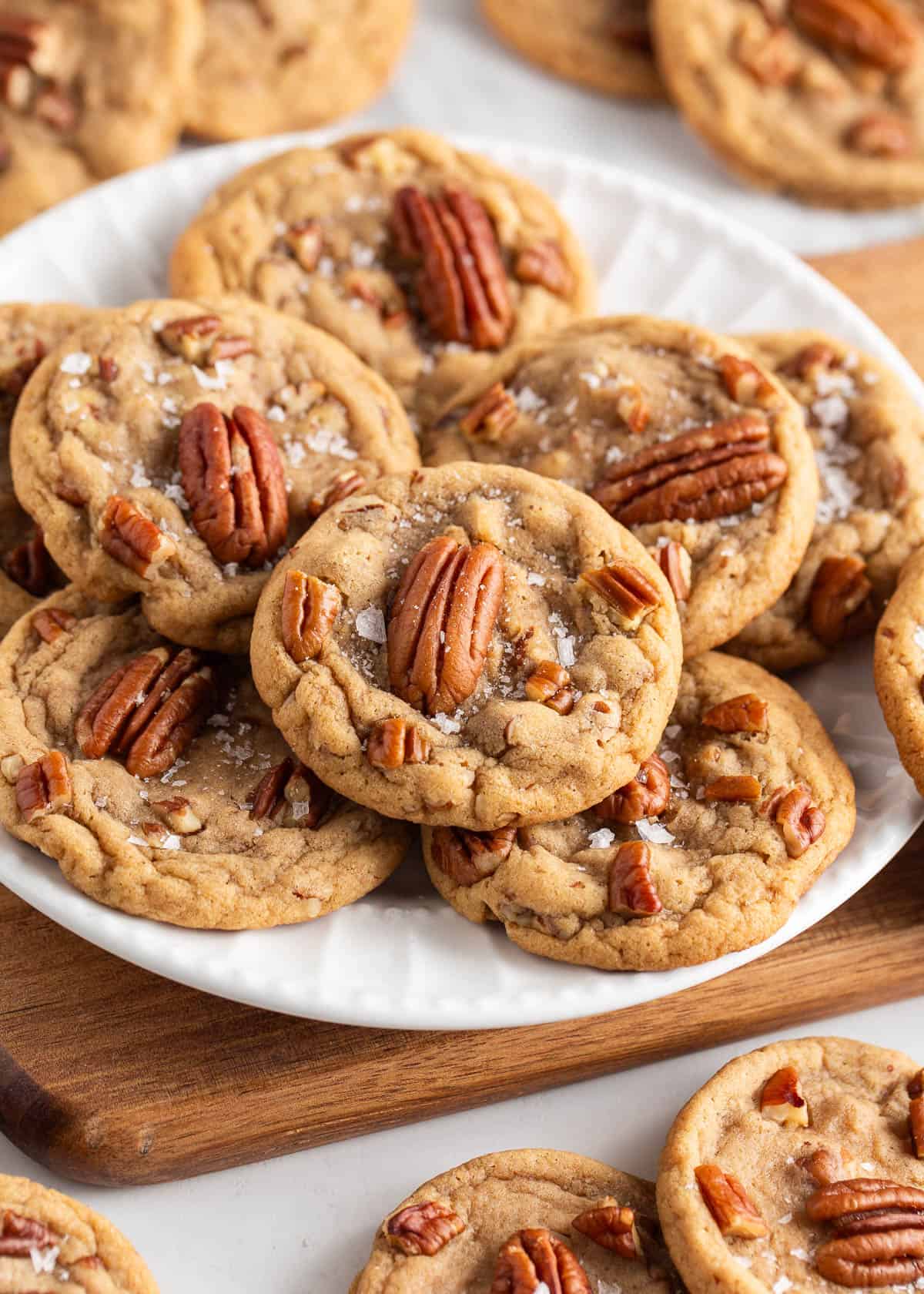 These soft and chewy butter pecan cookies have the delicious flavor combination of brown sugary goodness and nutty toasted pecans and are ready in 30 minutes! Butter pecan cookies on on a white plate.