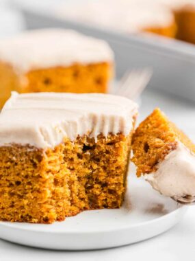 Pumpkin cake with a bite taken on white plate.