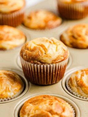 Pumpkin cream cheese muffins in a muffin pan.