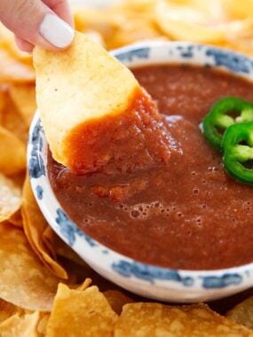 Corn tortilla chip dipped into smooth copycat Chili&rsquo;s salsa with mild Tex-Mex flavor.