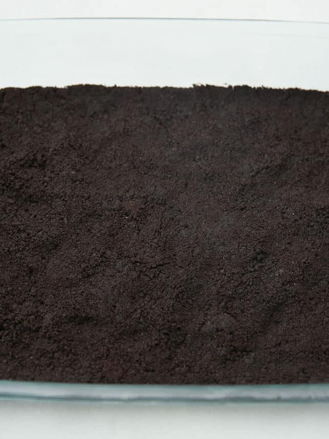 Oreo dirt crust in a 9x13 baking dish.