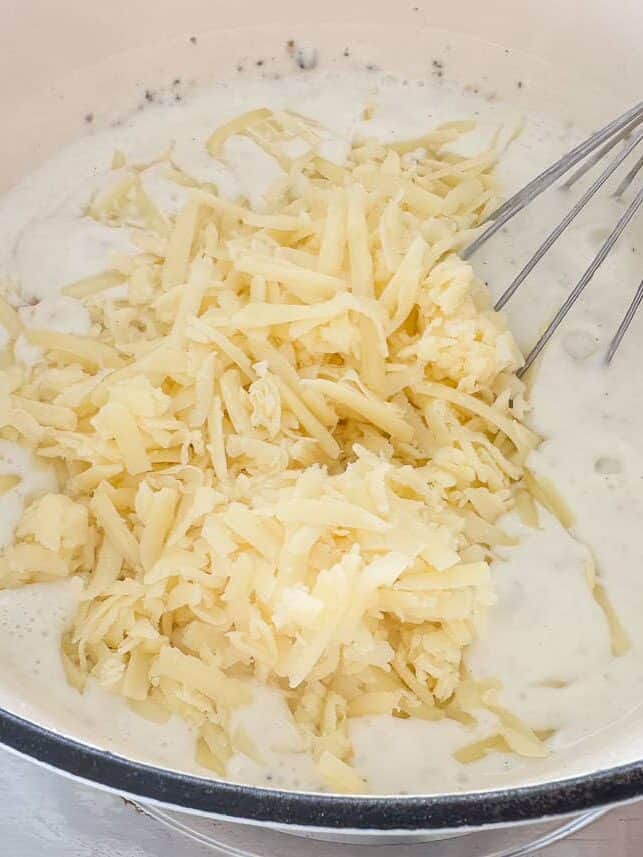 Added shredded white cheddar cheese into a pot.