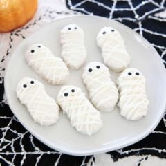 Mummy cookies on a white plate.