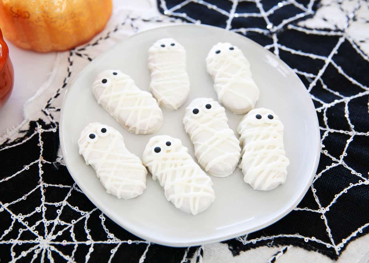 Mummy cookies on a white plate.