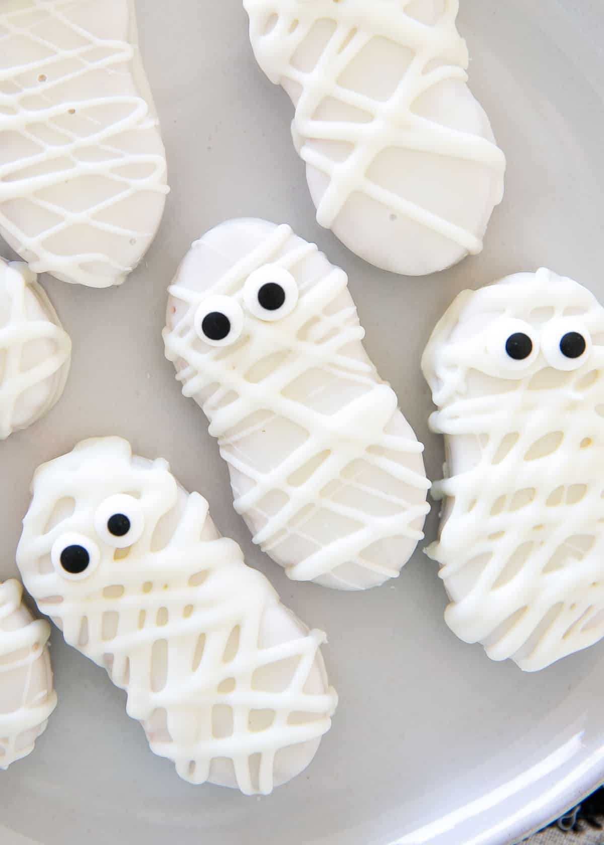 Mummy cookies on a white plate.