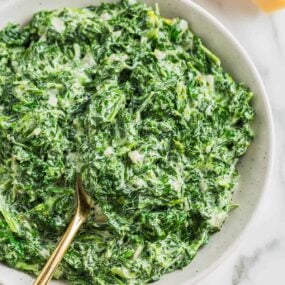 Creamed spinach in a white bowl.