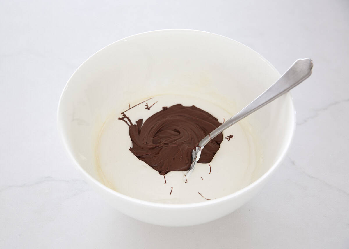 Mixing cool whip and chocolate in a bowl.