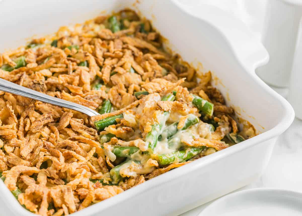 A southern green bean casserole inspired by Paul Deen's recipe in a white baking dish.