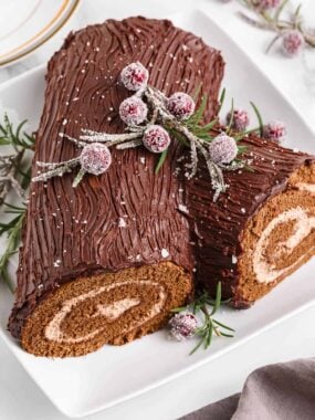 Yule log cake with cranberries on top.