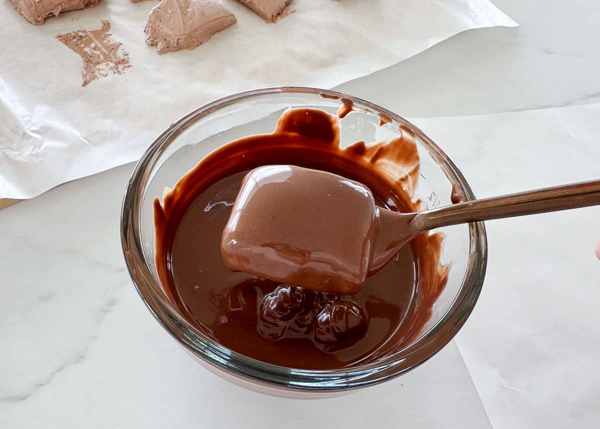 Dipping cool whip candy in chocolate.