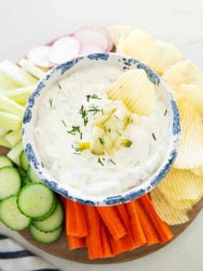 Dill pickle dip with vegetables and chips.