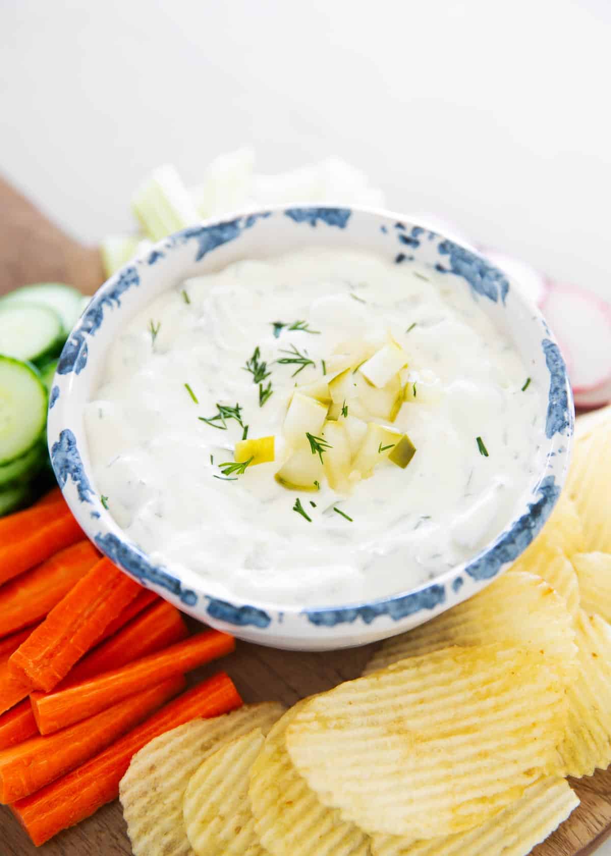 Dill pickle dip in a white bowl.