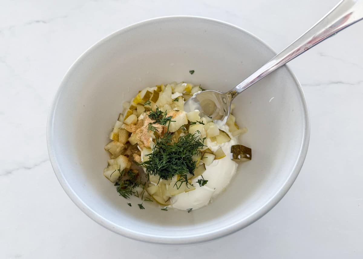 Showing how to make dill pickle dip.