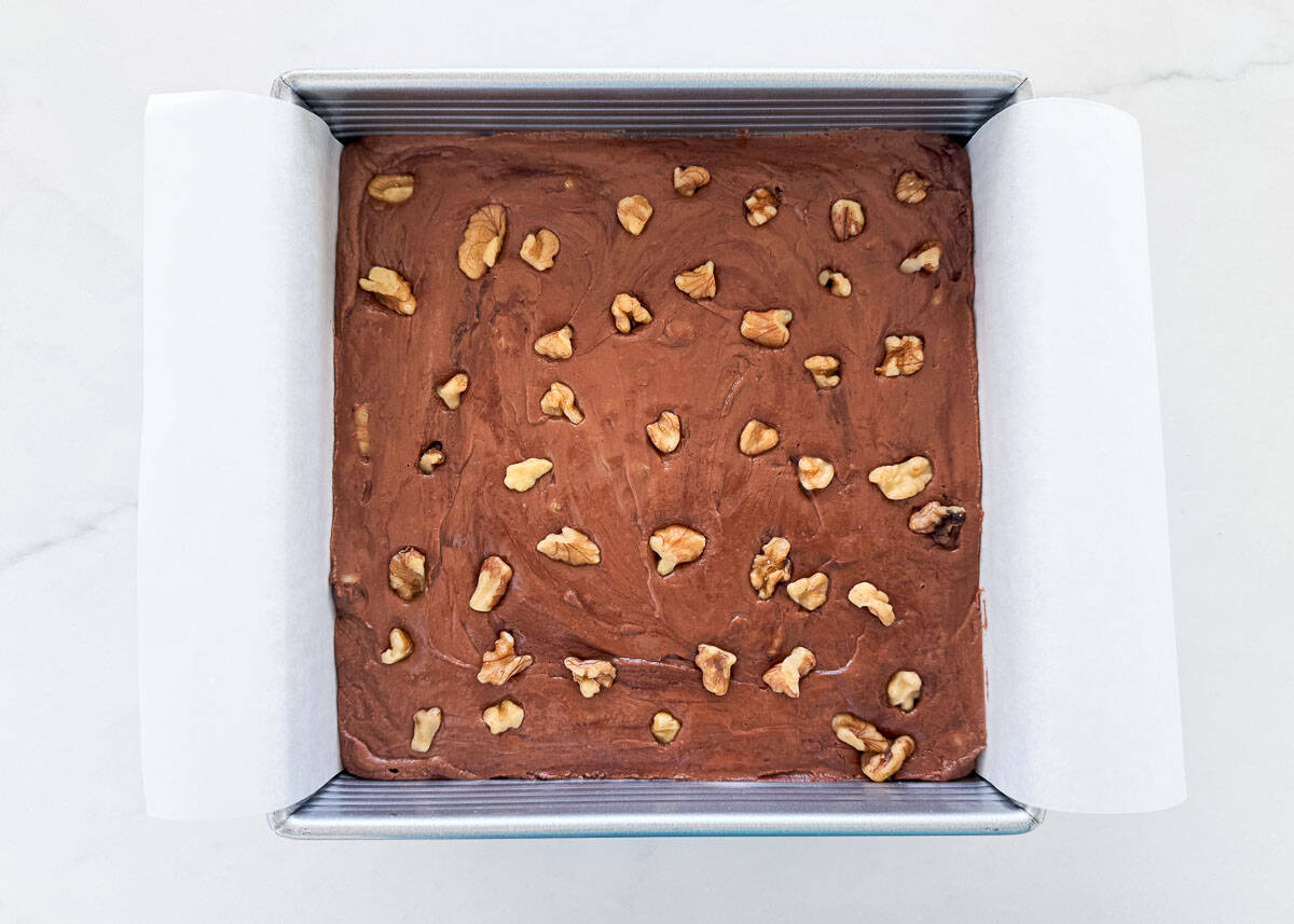 Just like the original recipe from the back of the Kraft marshmallow creme jar, fantasy fudge is a classic holiday treat for Christmas made with chocolate chips and walnuts! Fantasy fudge recipe in a parchment lined pan.