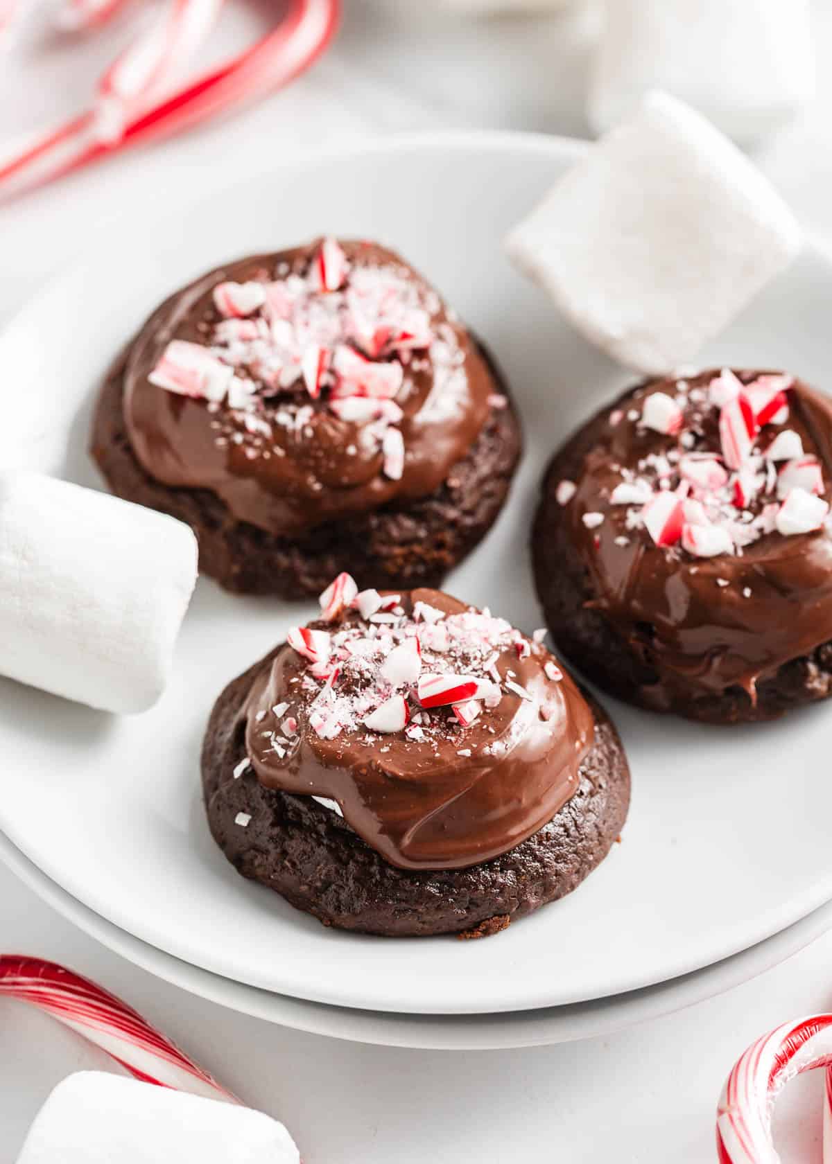 Chocolate marshmallow cookies with candy canes on top.