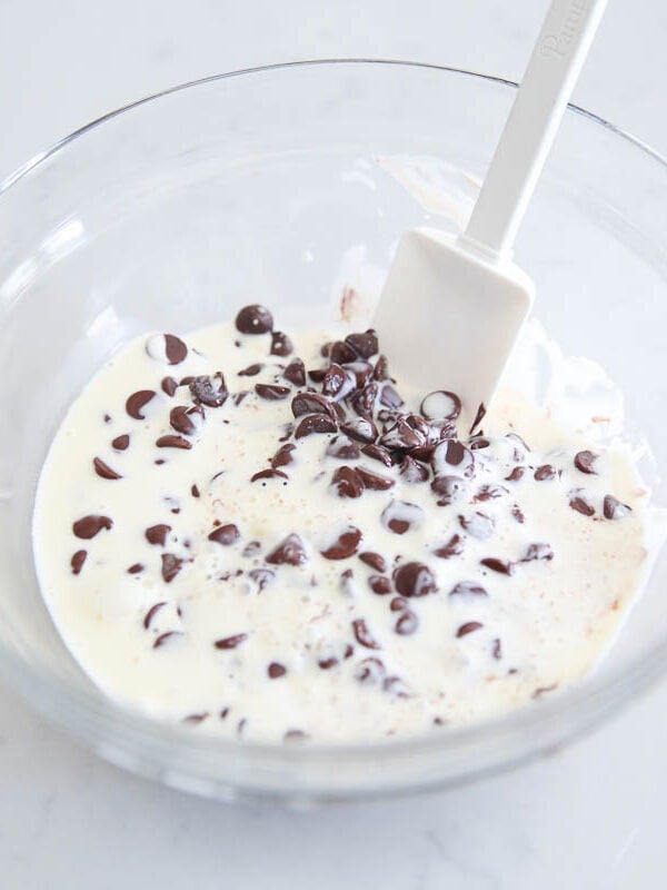 Heavy cream and chocolate chips in a bowl.